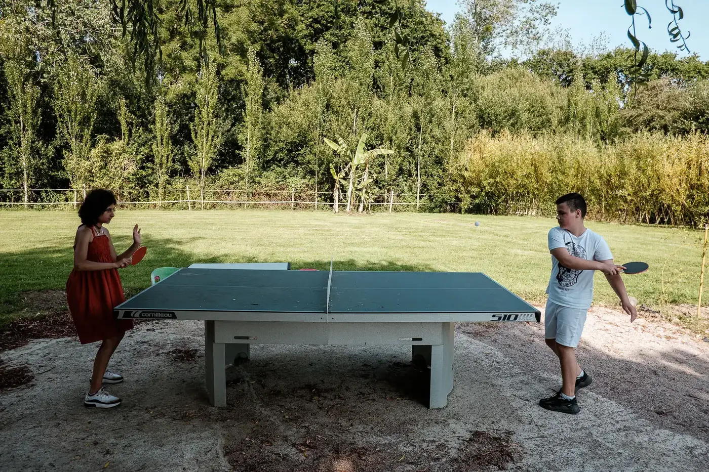 Table de ping-pong dans le jardin verdoyant du Domaine de l'Entre-Deux
