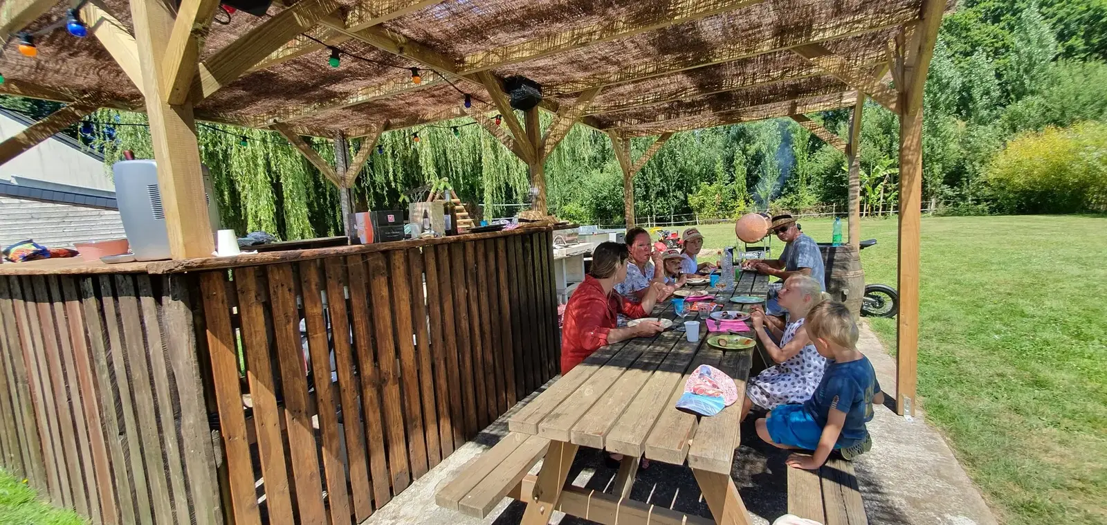 Repas convivial sous la terrasse couverte du gîte de groupe