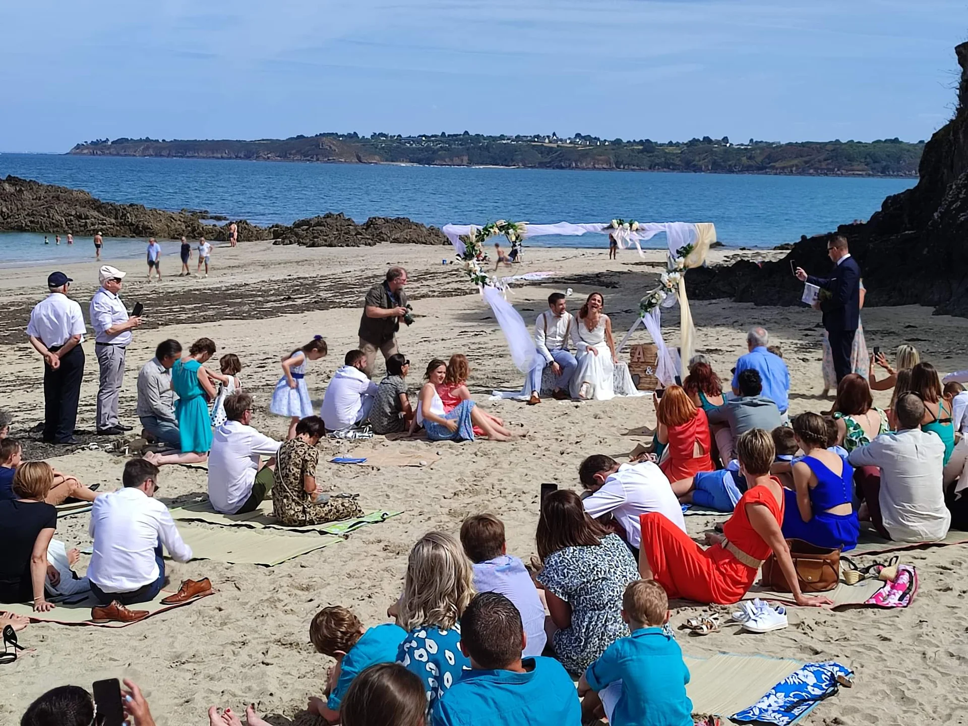 Ceremonie laique de mariage sur la plage de la Cote d'Emeraude avec arche fleurie et invites - Domaine de l'Entre-Deux Plevenon Bretagne